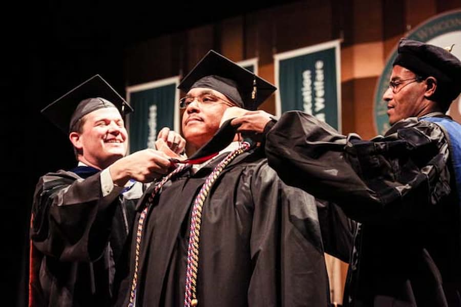 Master's student accepts cords showing high achievement at commencement ceremony