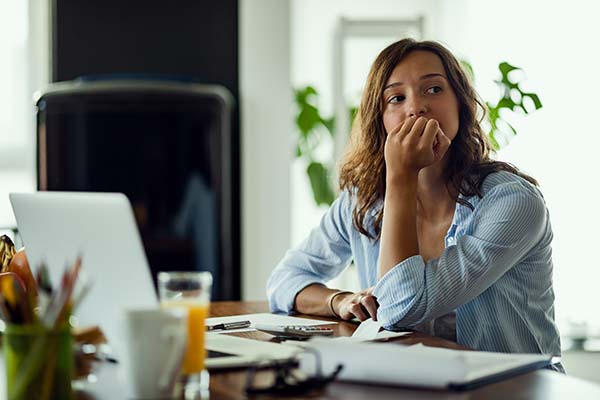 woman worrying looking off into distance while working at home