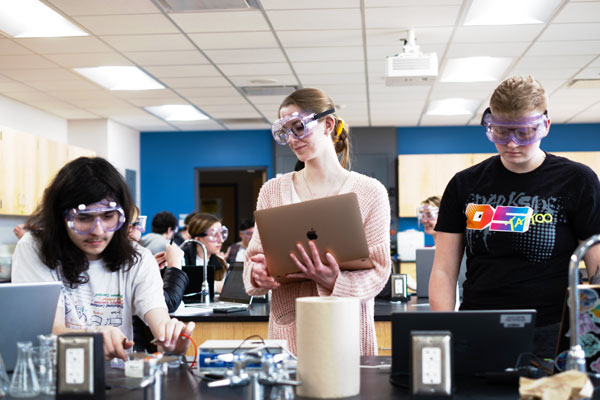 Three chemistry students working Erlenmeyer Flasks