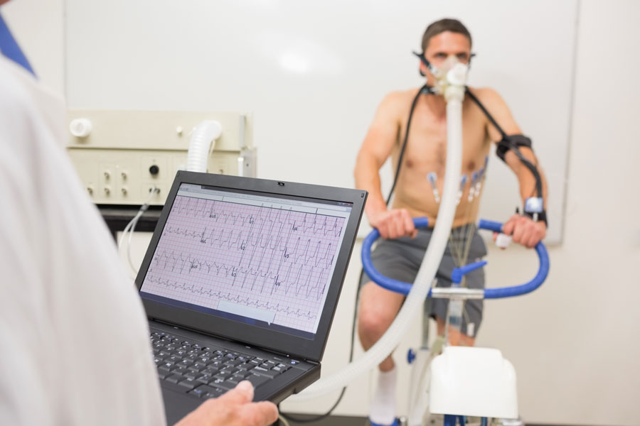 Male taking oxygen test on exercise bike