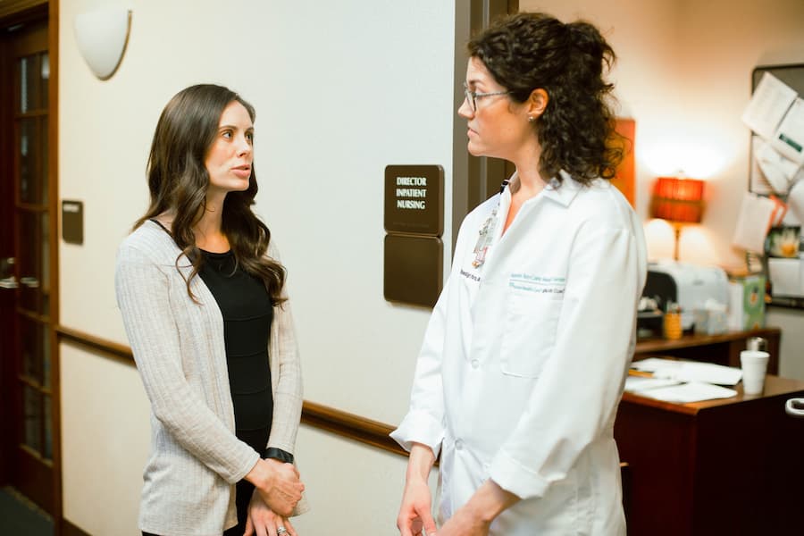 Nurse administrator talks with doctor in clinic