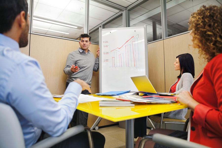 Business analytics employee draws data chart on white board