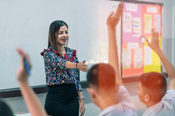 teacher calling on students with their hands raised