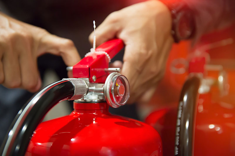 Pulling safety pin of fire extinguisher