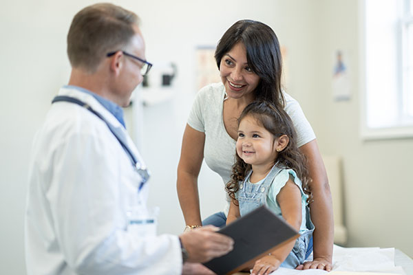 mom with young daughter talking to doctor