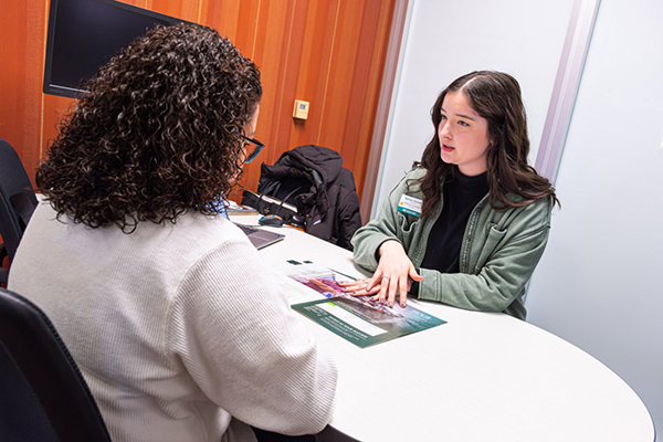 Two females meeting at a desk workspace