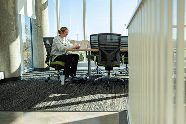Student working on a laptop in conference room
