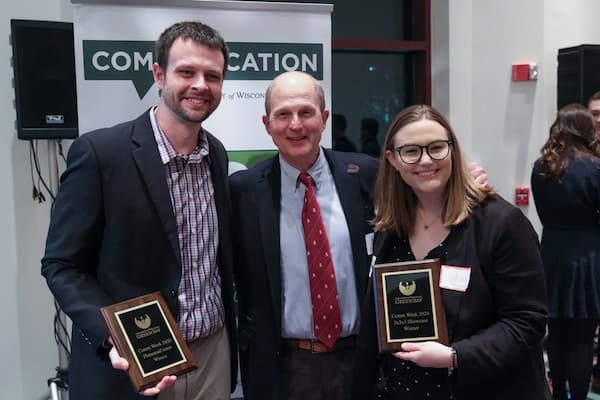 Three communication professionals pose with awards
