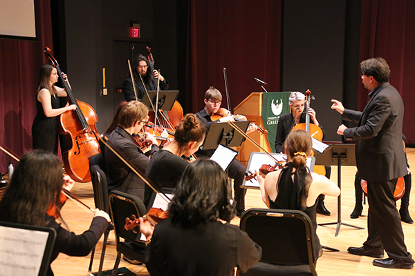 an instructor conducting a orchestra