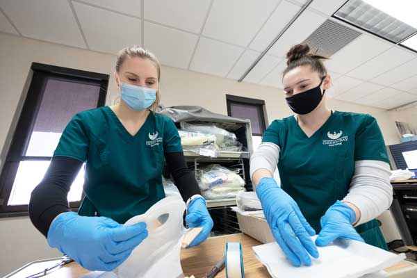 Two nurses work with patient