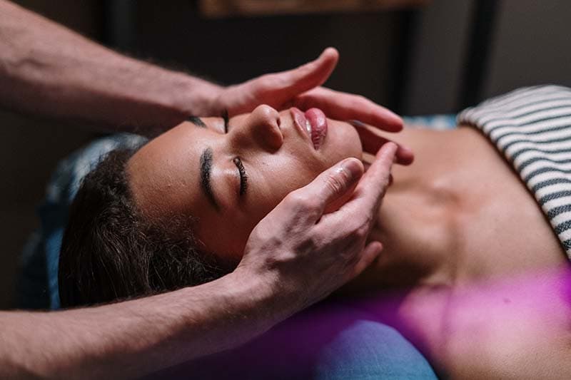 massage therapist giving a face massage