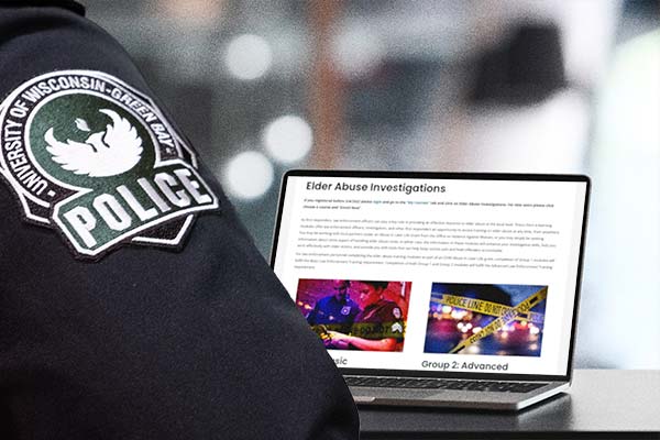 View over a shoulder a police uniform shoulder of a laptop showing elder justice training.