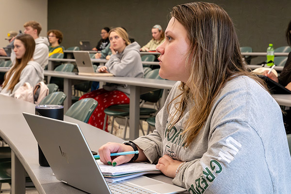 Student taking notes in classroom setting