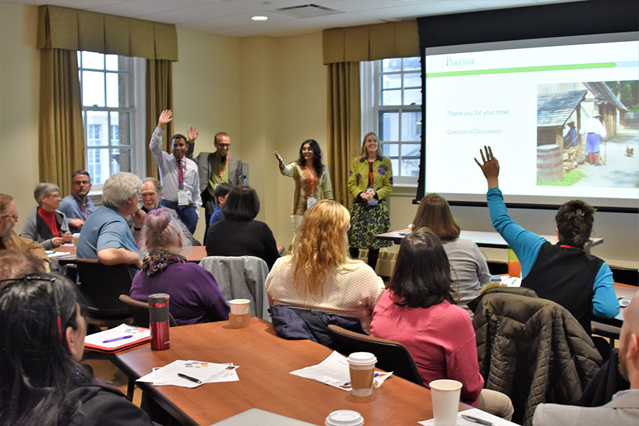 Instructors raising hands during presentation