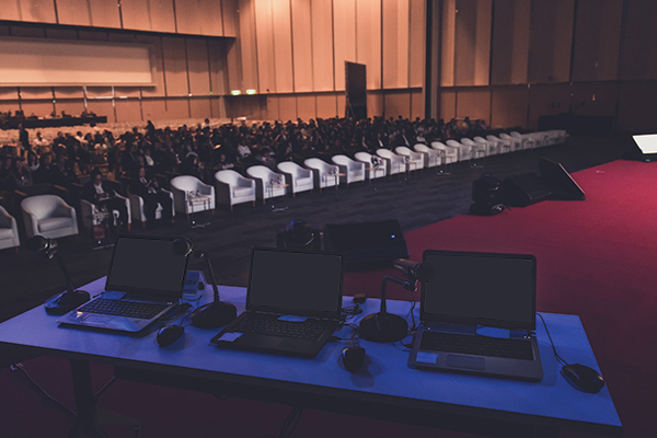 A moody lit conference room with laptops and chairs