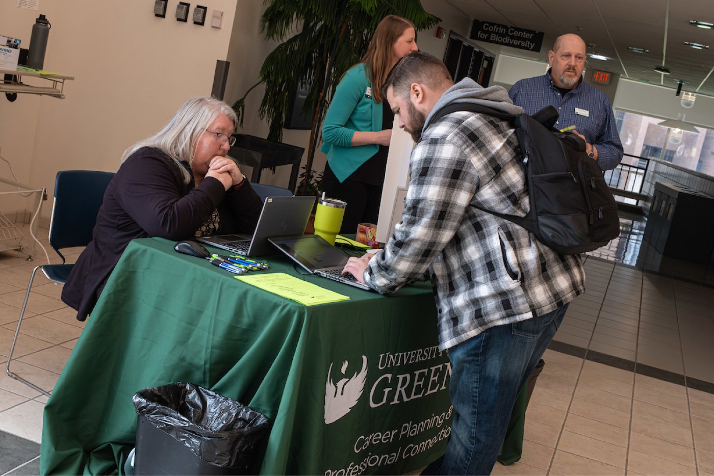 Chris Cox, a Career Planning & Professional Connections staff member, assists a student at a resource fair event.