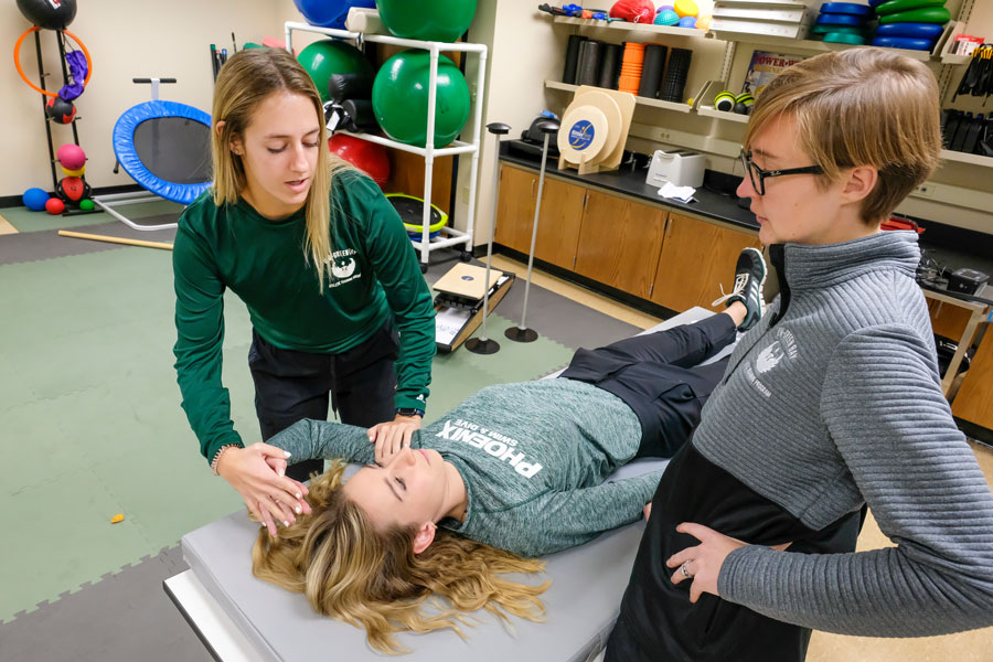 Students practicing healing stretches on peer