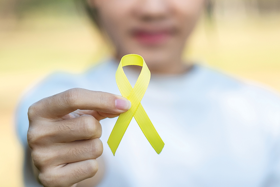 Young girl out of focus holding out a yellow ribbon