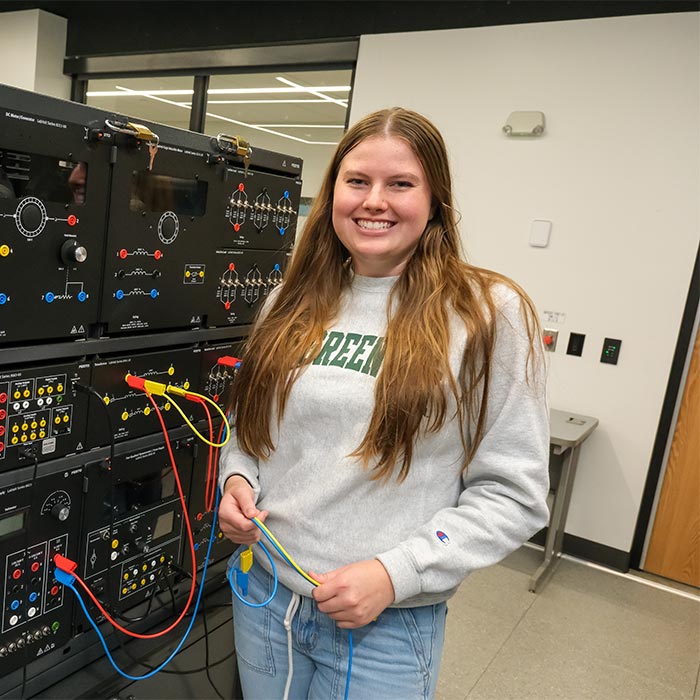 Chloe Meulemans, an Electrical Engineering student, poses in the Electrical Machines Lab.