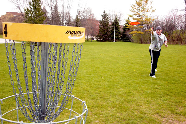 Young man plays disc golf