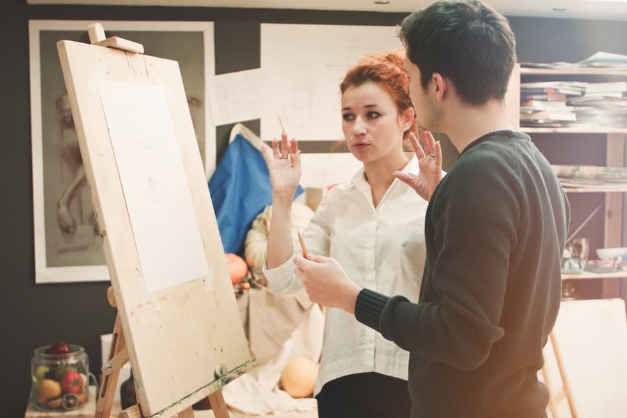 Teacher helps student in drawing studio