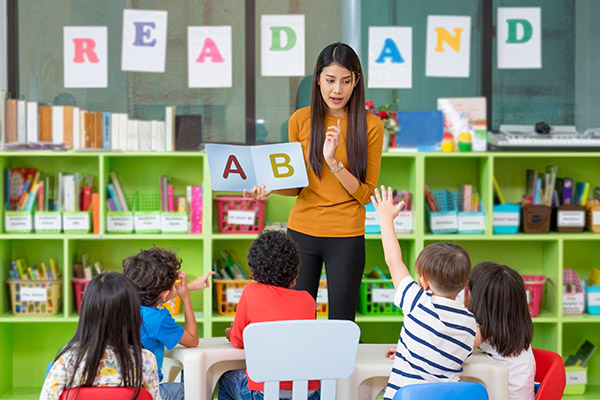 Teacher with young students teaching the alphabet