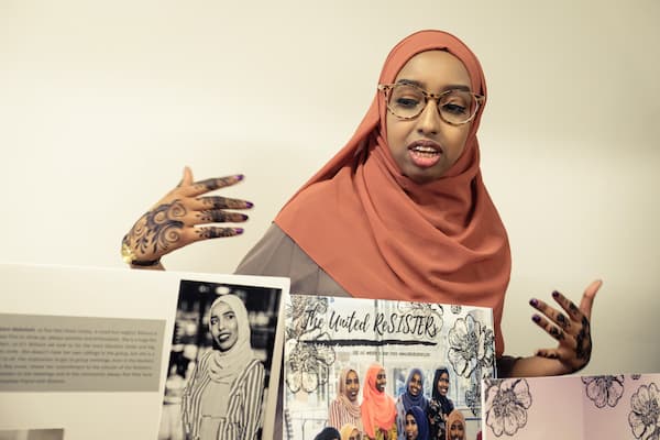 Somali female student in hijab presents her projects during multicultural event.
