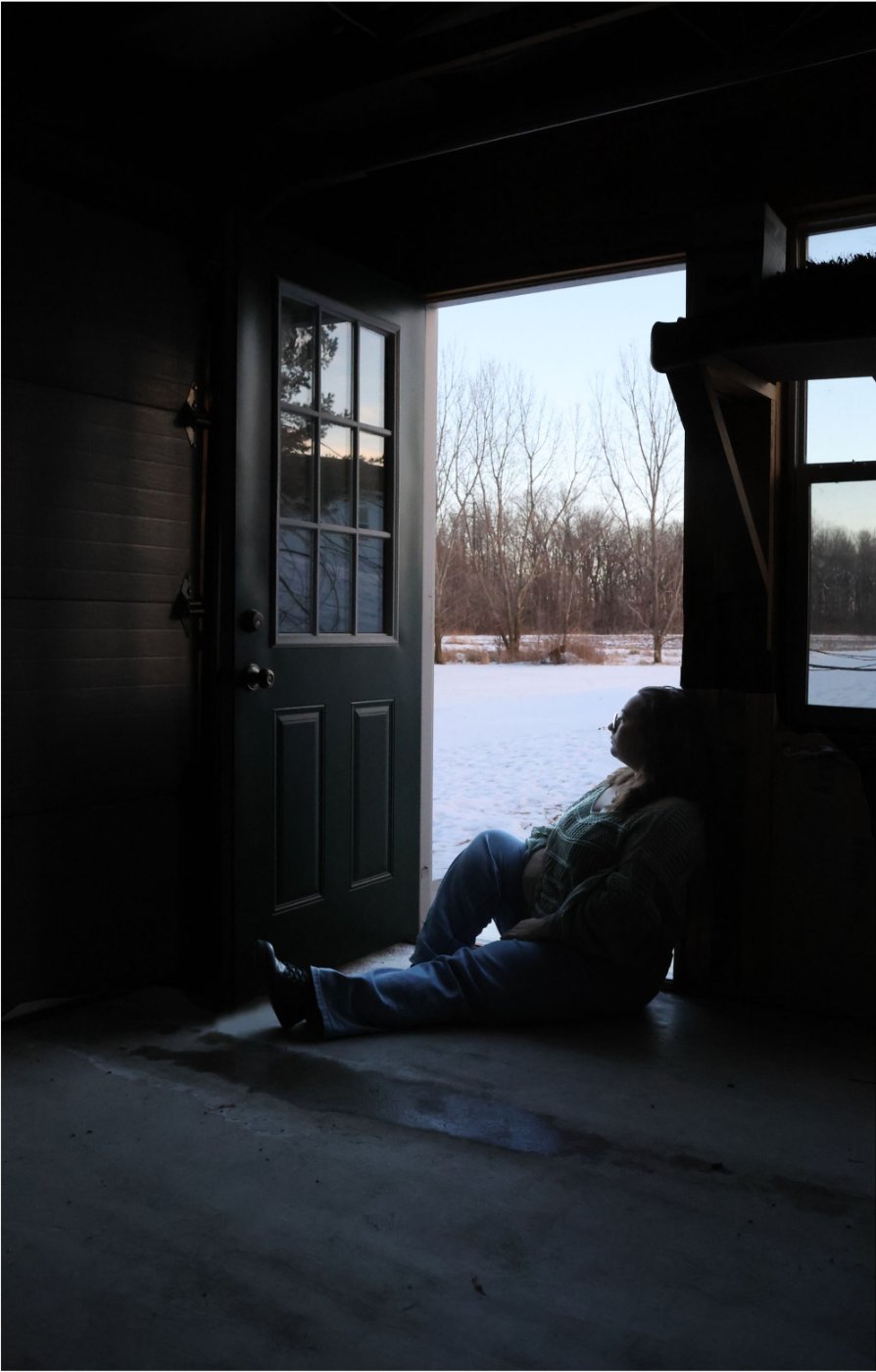Photo of a person silhouetted in a doorway sitting on the floor.