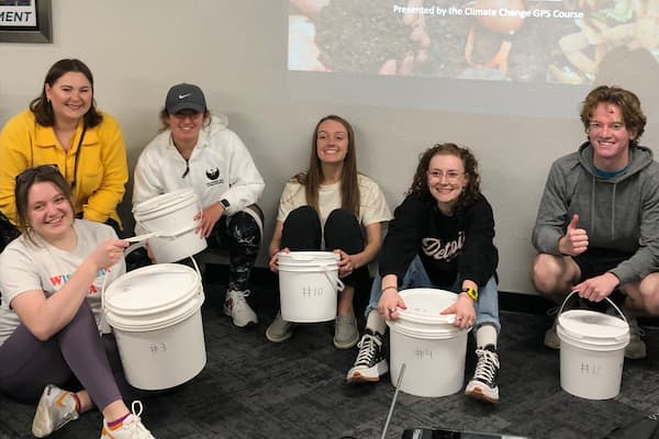 UW-Green Bay students with buckets running a residential composting pilot program for their service learning project.