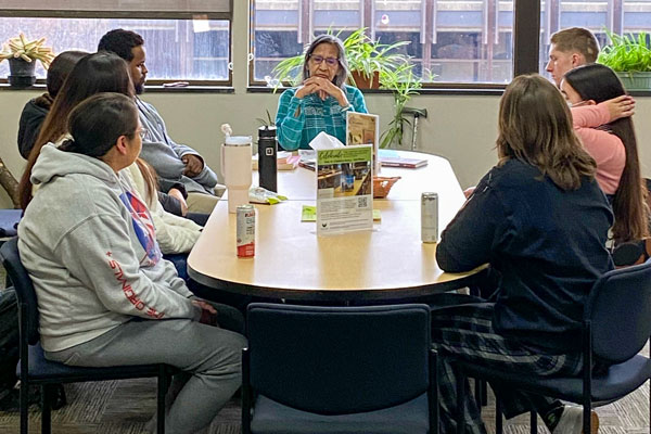 Student and professor talking at table