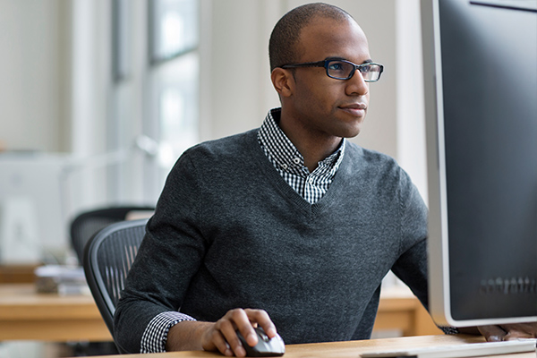 Man working at desk with mouse in hand