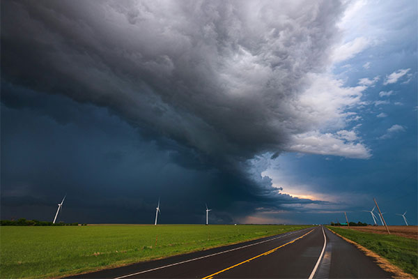 Thunderhead clouds along a weather front over a field of wind turbines