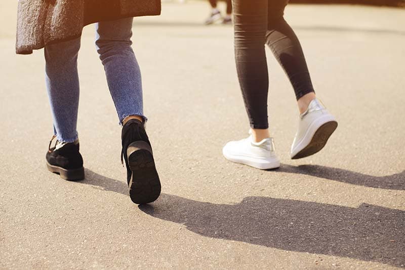 two people walking together outside sunny