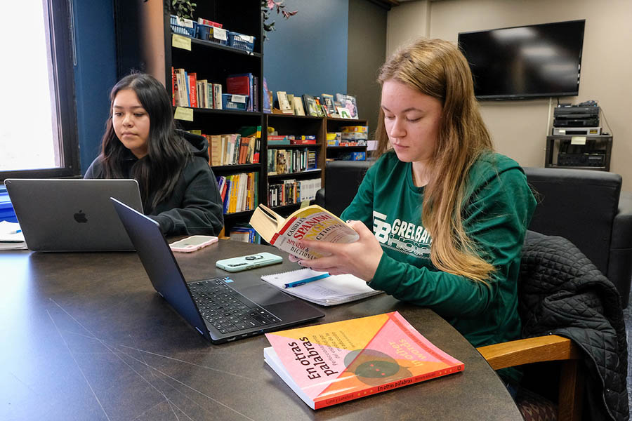 Students with laptop and Spanish translation books