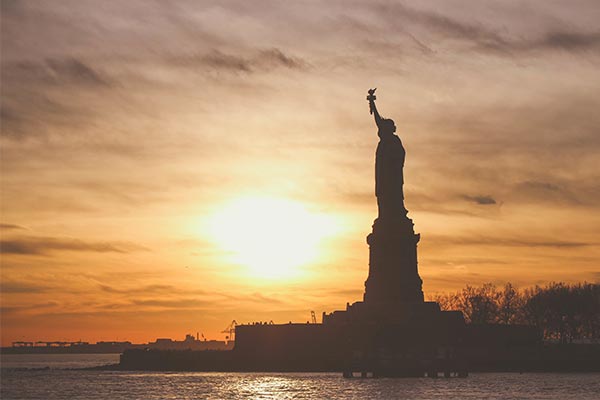 Sun behind the Statue of Liberty