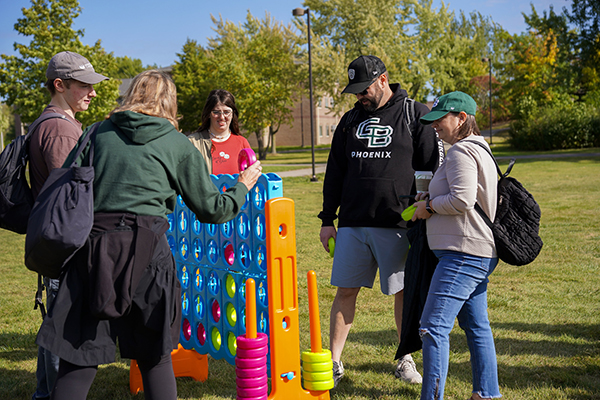 A family plays a giant Connect 4 yard game at Phoenix Family Weekend