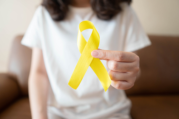 Young woman holding out a yellow ribbon