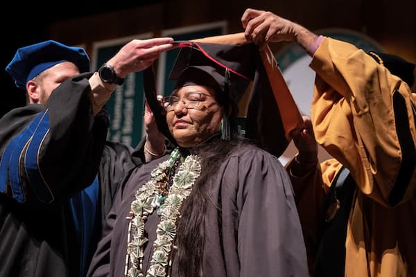 Native American graduate student receiving stole at commencement