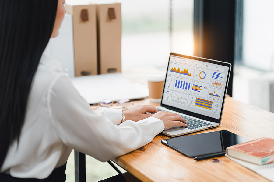 Business woman on laptop with financial charts