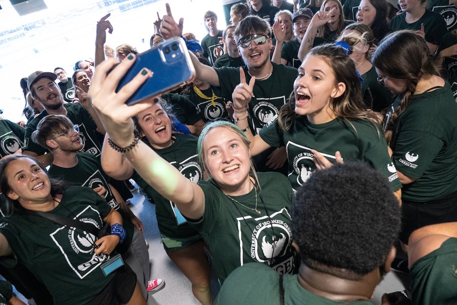A large crowd of students gather at Lambeau Field for their civic engagement celebration in September 2022. Students in the foreground pose for a selfie.