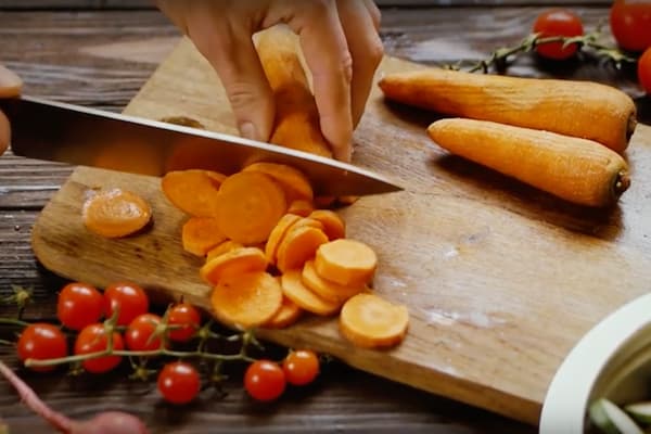 Close up of person cutting carrots