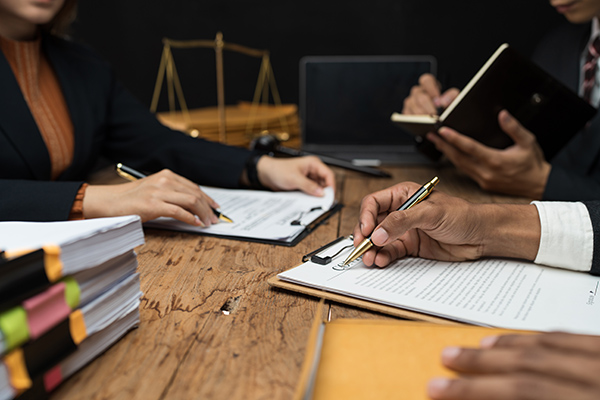 Closeup of desktop and people reviewing files on clipboards