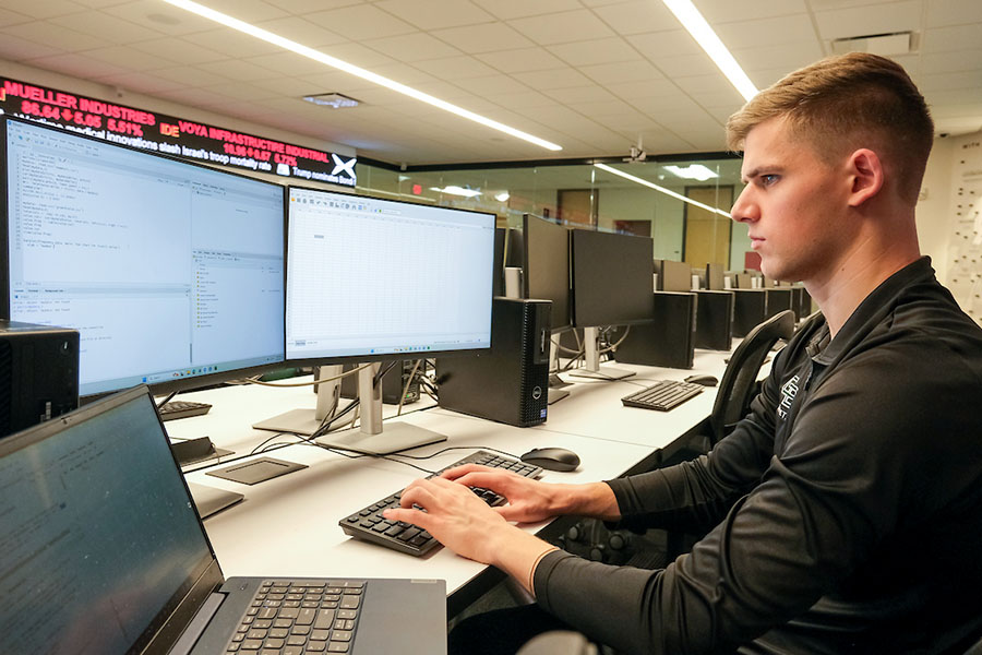 Student working in front of multiple monitors