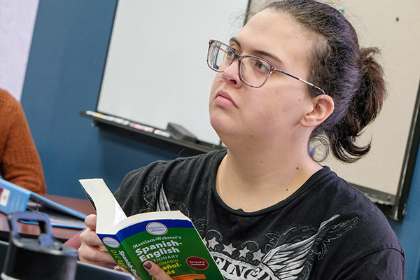 Student with Spanish-English translation book