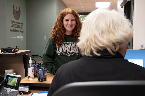 Student at the UWGB Wellness Center reception desk.