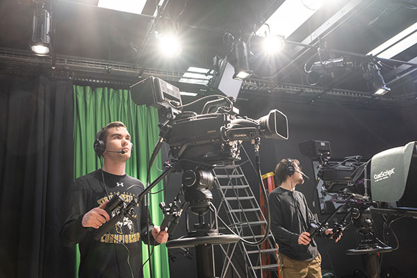 Man operating a camera in tv studio