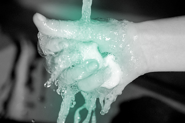 hand under running water holding soap