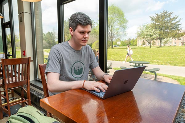 UWGB MPA student Gage Beck workign on his laptop in the Union.