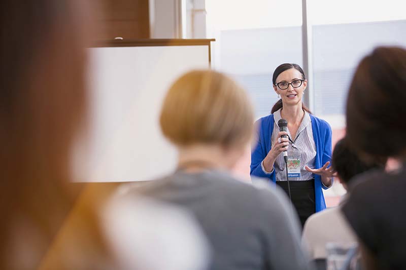 woman presenting at a conference