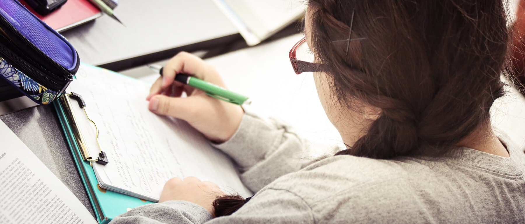 A UWGB student takes notes in class.